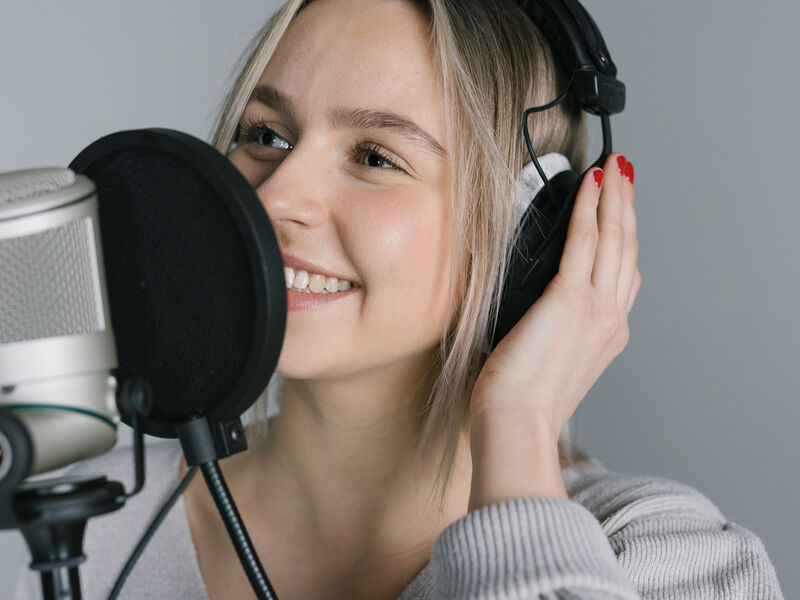 Frau mit Kopfhörer am Mikrofon